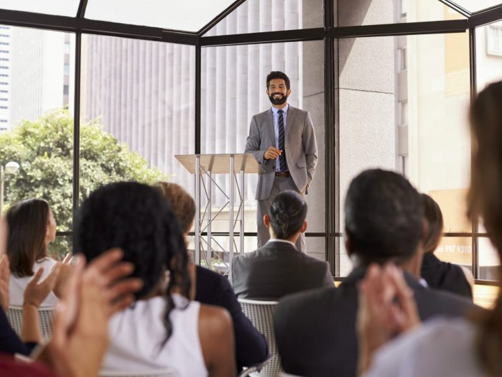 man in front of small crowd speaking, author speaker